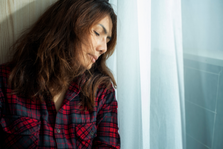 disappointed woman leaning against the window