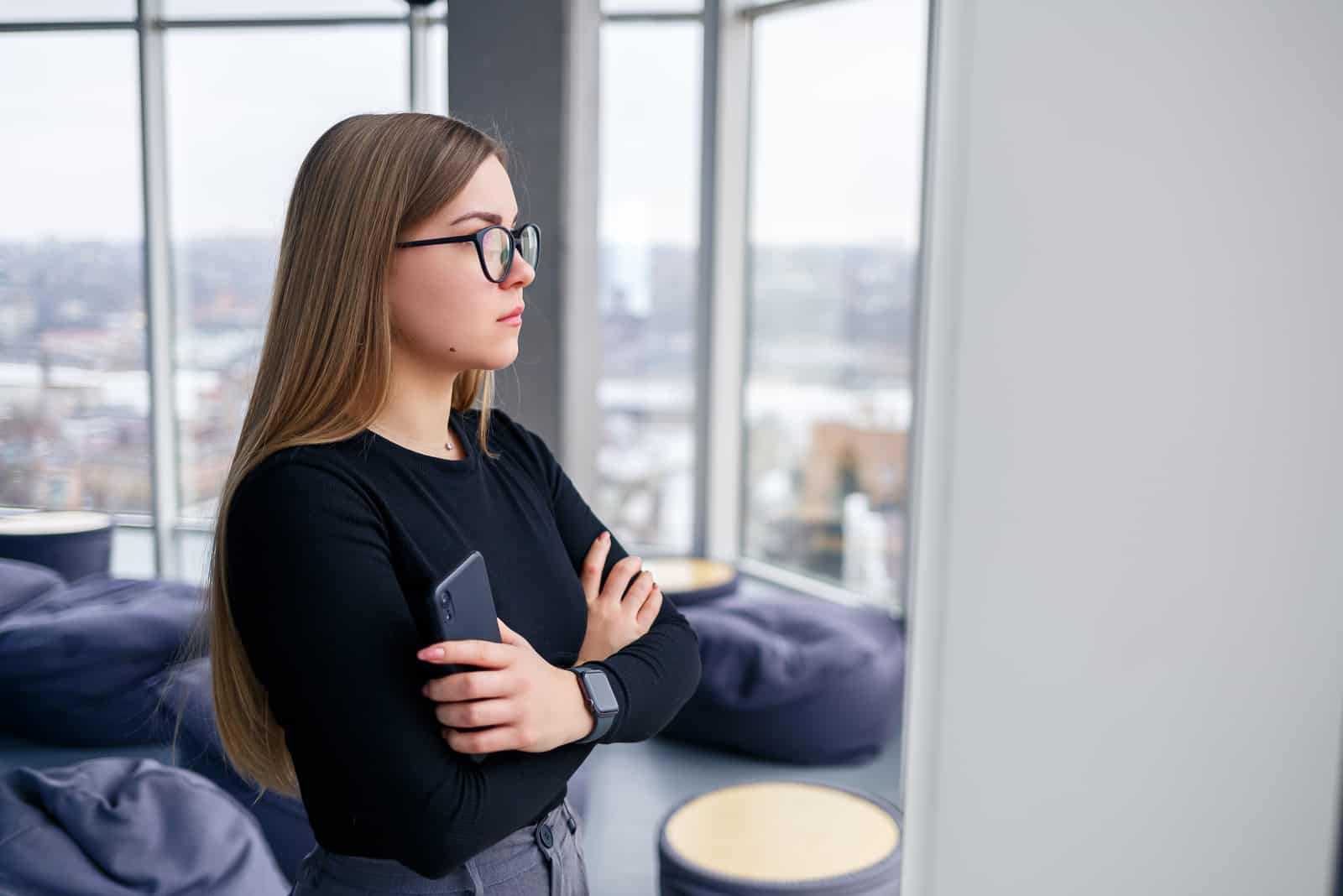 woman standing by window thinking about her ex