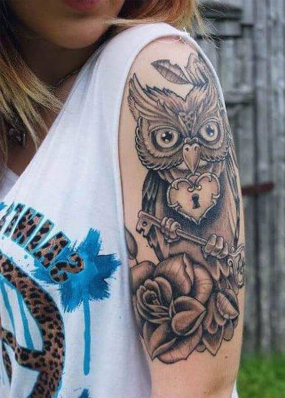 Tatuaje de búho con cerradura y llave en el brazo