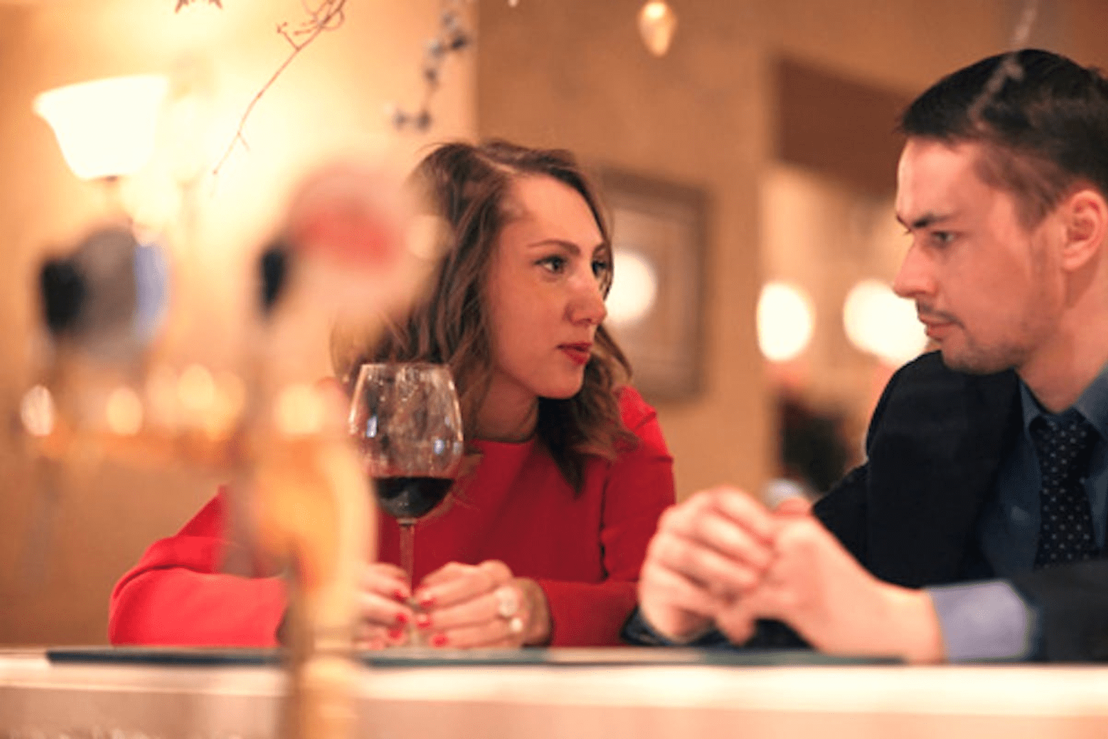 a man and a woman are sitting at a table in a cafe and talking