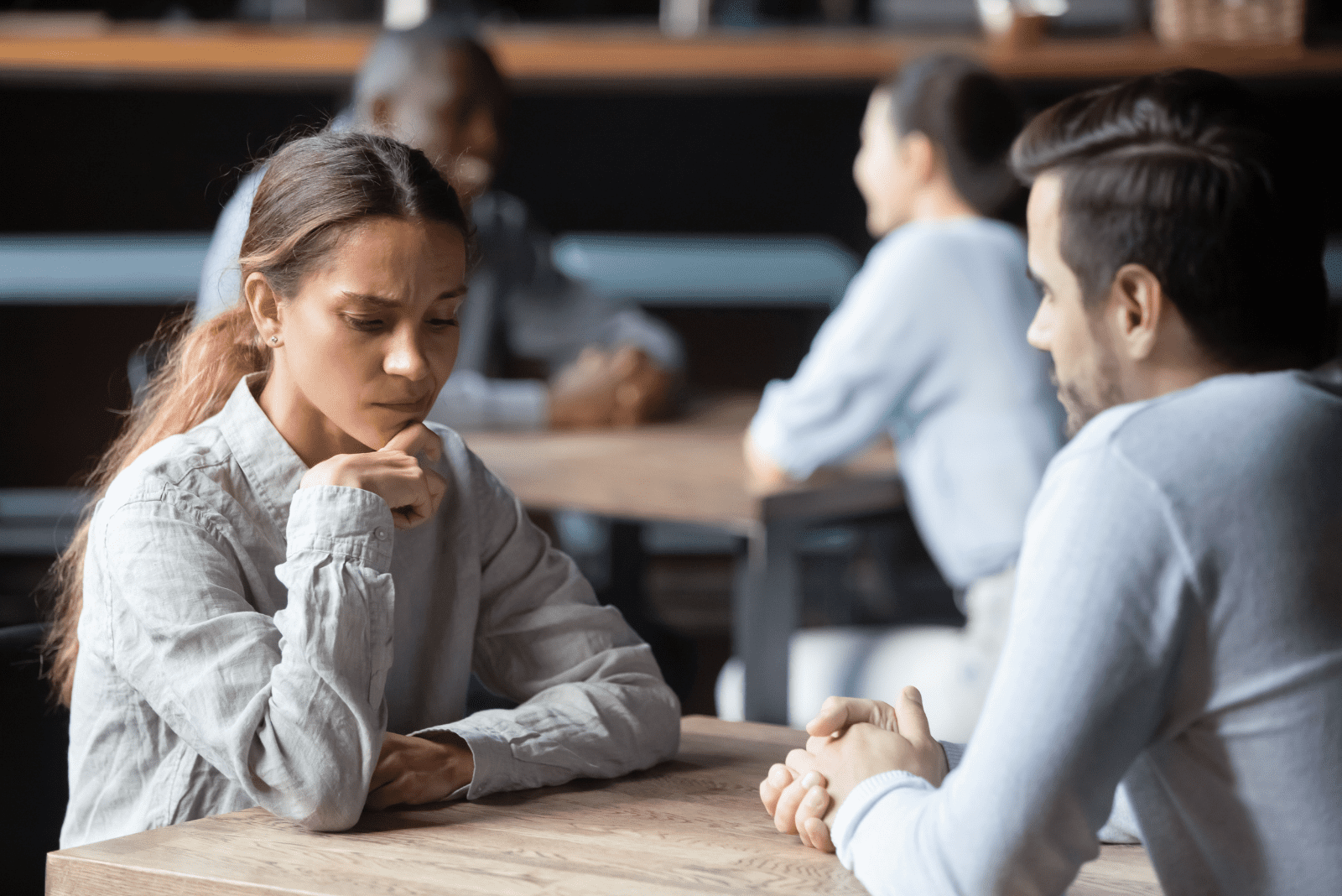 um homem e uma mulher estão sentados à mesa a conversar 