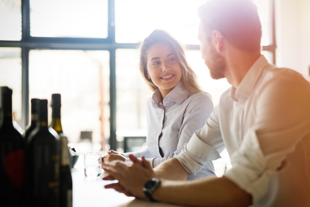 a smiling woman with long brown hair is talking to a man