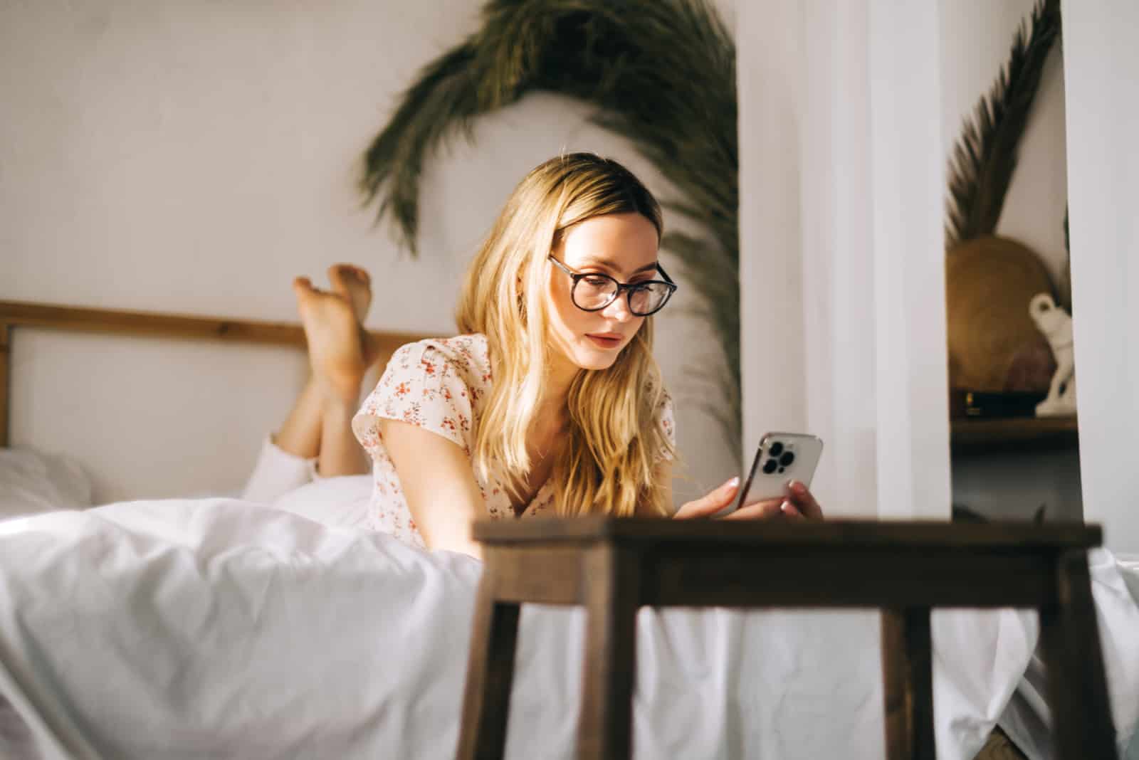 rubia con gafas escribe en el teléfono