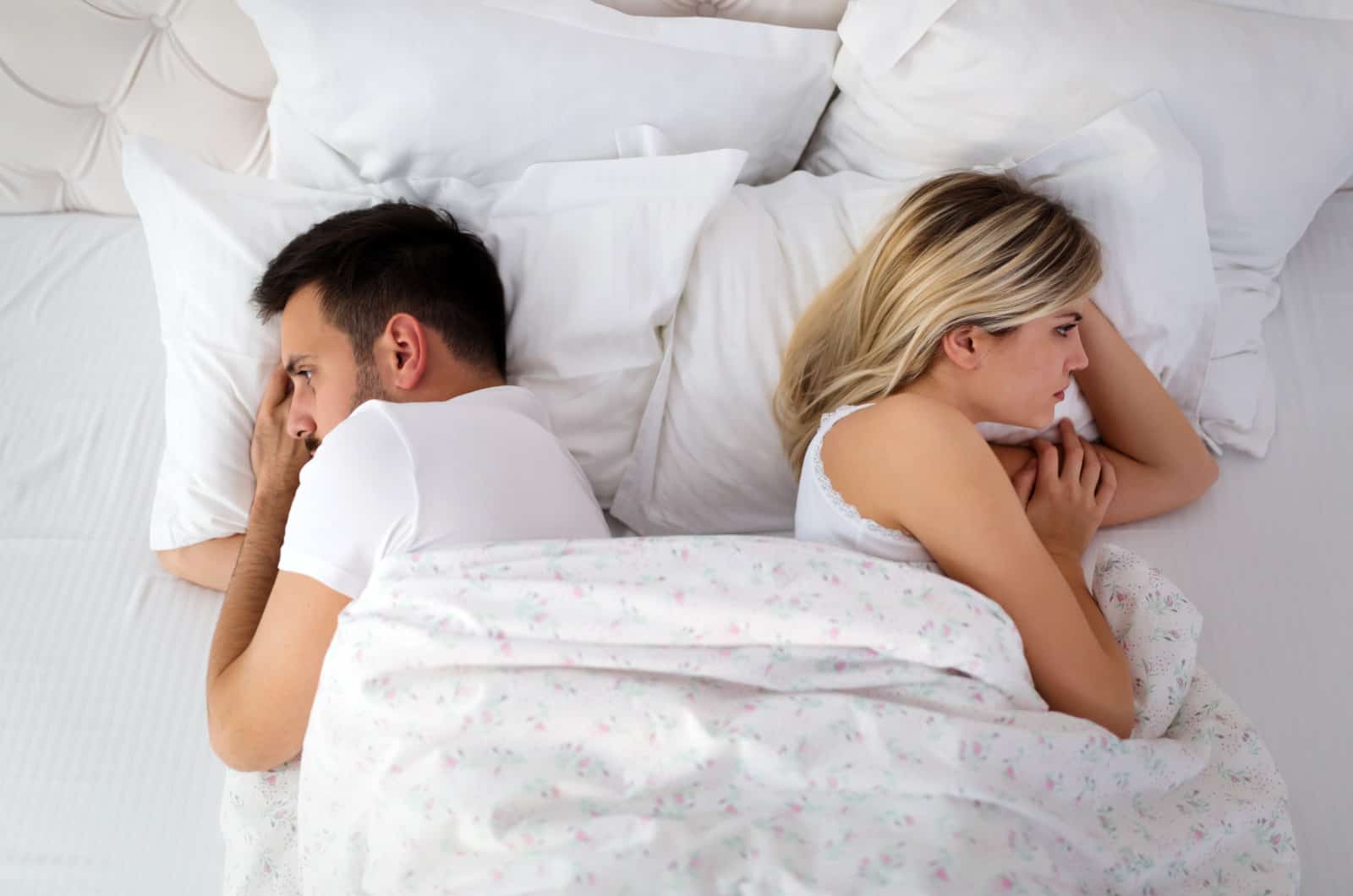 couple in bed facing away from each other