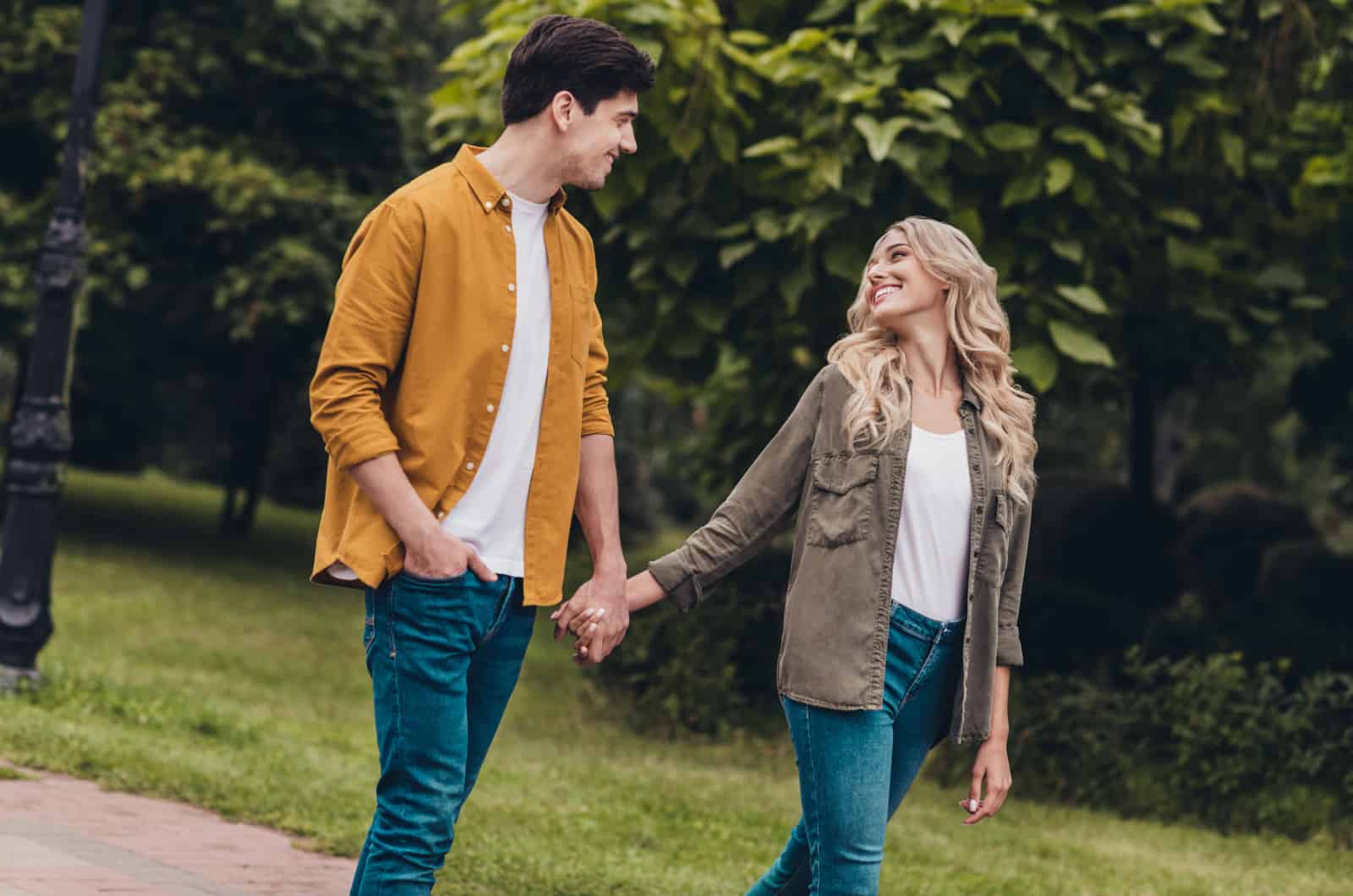 couple holding hands while taking a walk