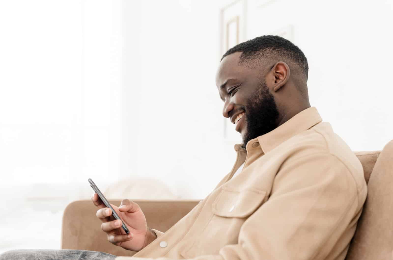 man smiling because of a flirty text he received