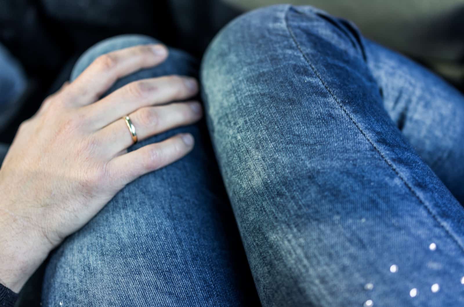 hombre con la mano en el muslo de la mujer mientras conduce haciéndole saber que está a su lado