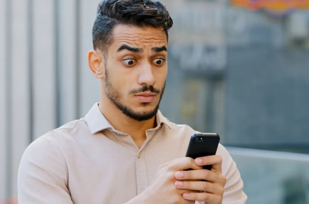 shocked man staring at his phone
