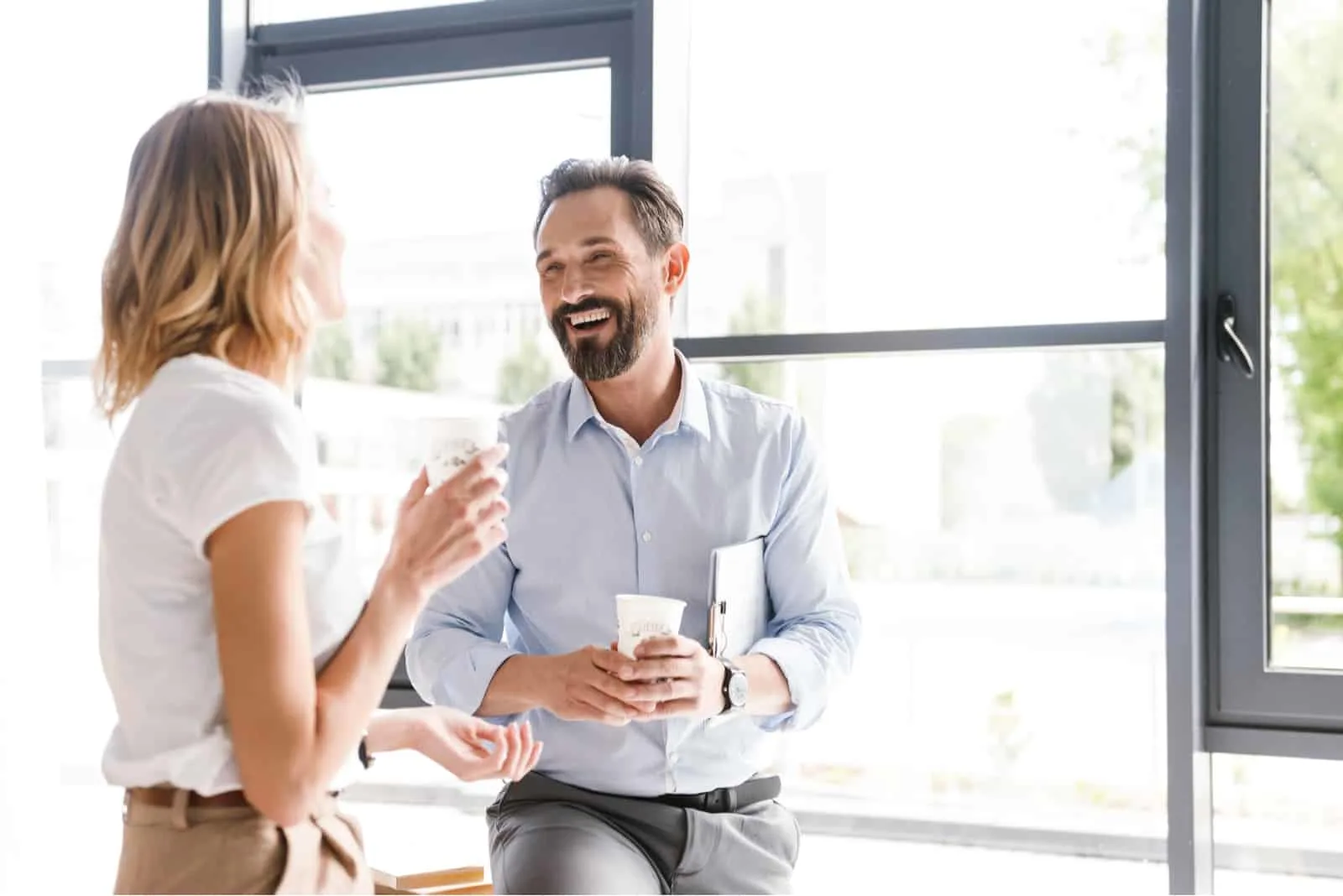 smiling man talking with woman in the office