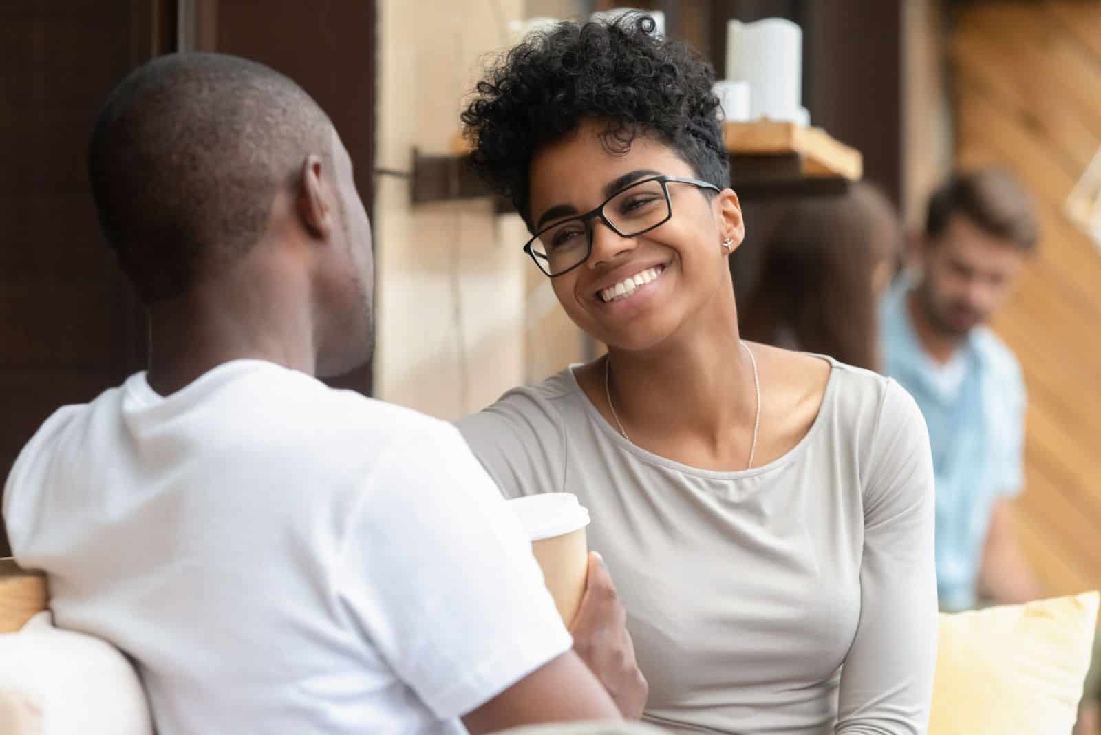 smiling woman with glasses talking to a man