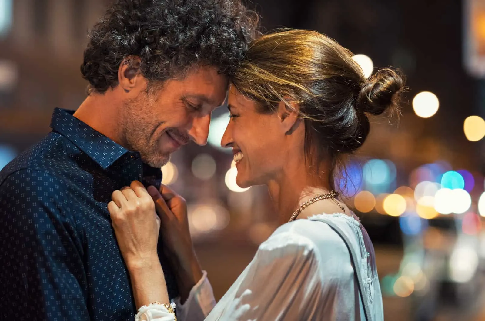 widowed woman smiling in man's embrace which is a sign she's ready to date