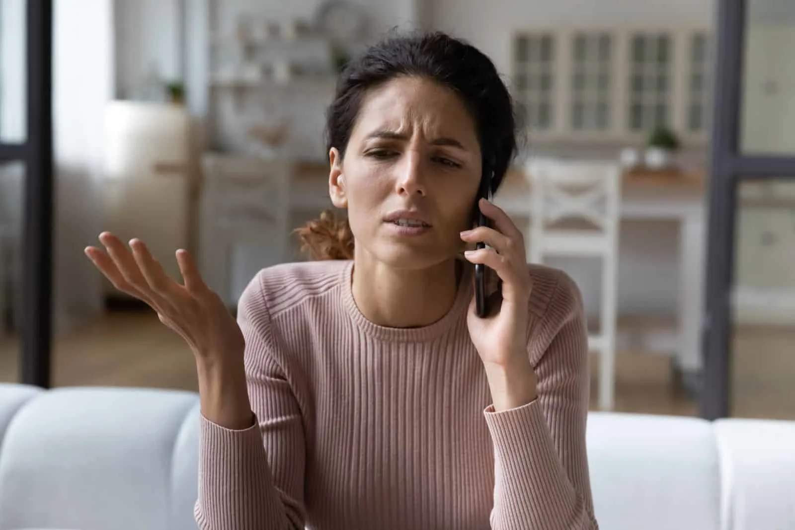 woman in a bad mood talking on the phone