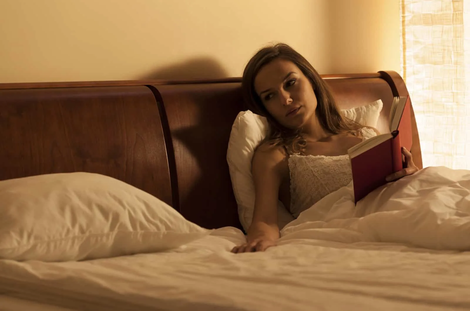 woman in bed looking at the empty spot next to her letting go of her late husband