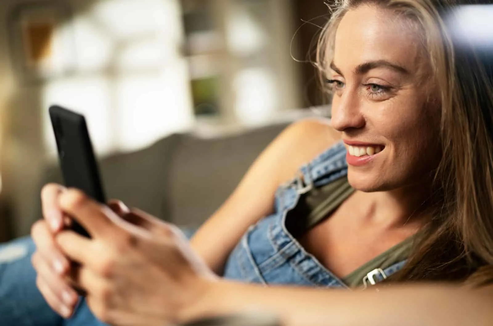 woman smiling while sending a funny text