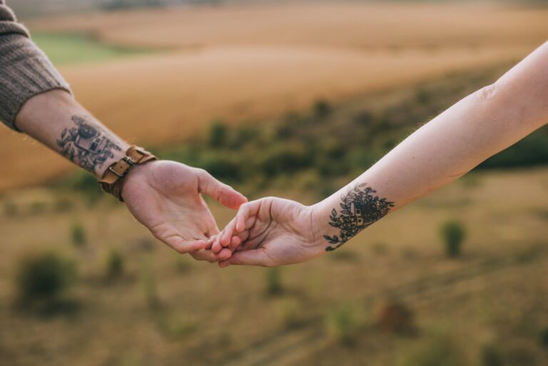 due sorelle tatuate che si tengono per mano