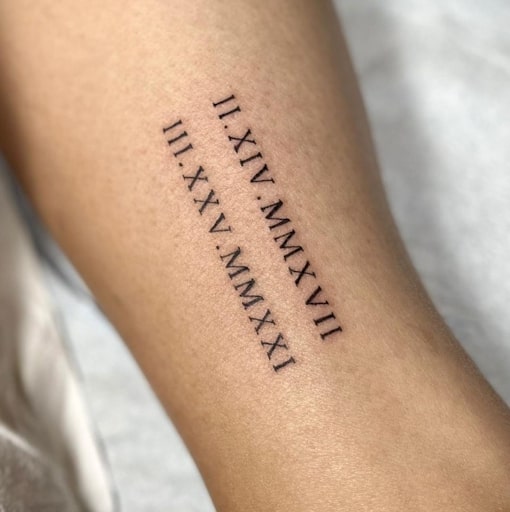 Tatuagem da data de nascimento em números romanos.