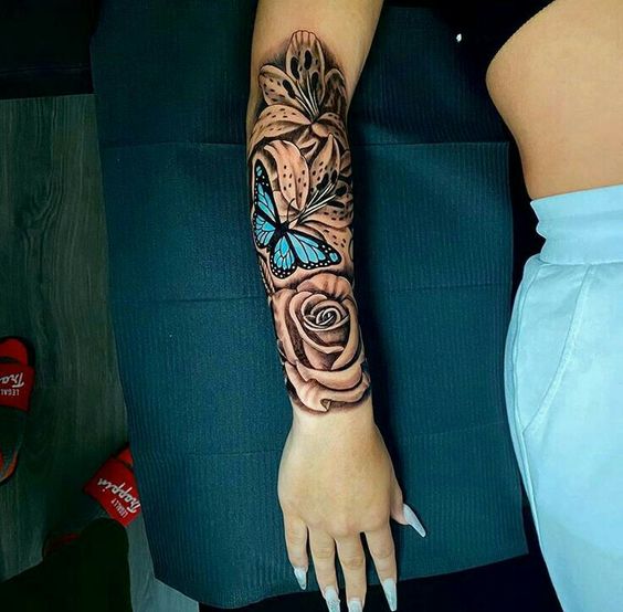 Tatuaggio a mezza manica con farfalla e rose sull'avambraccio