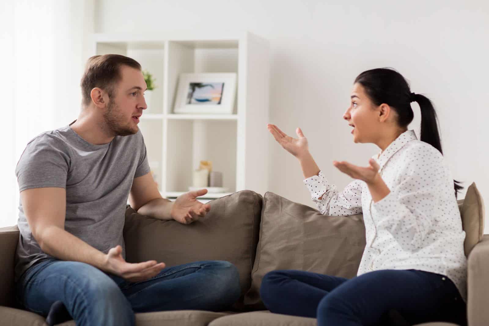 a man and a woman are arguing on the couch