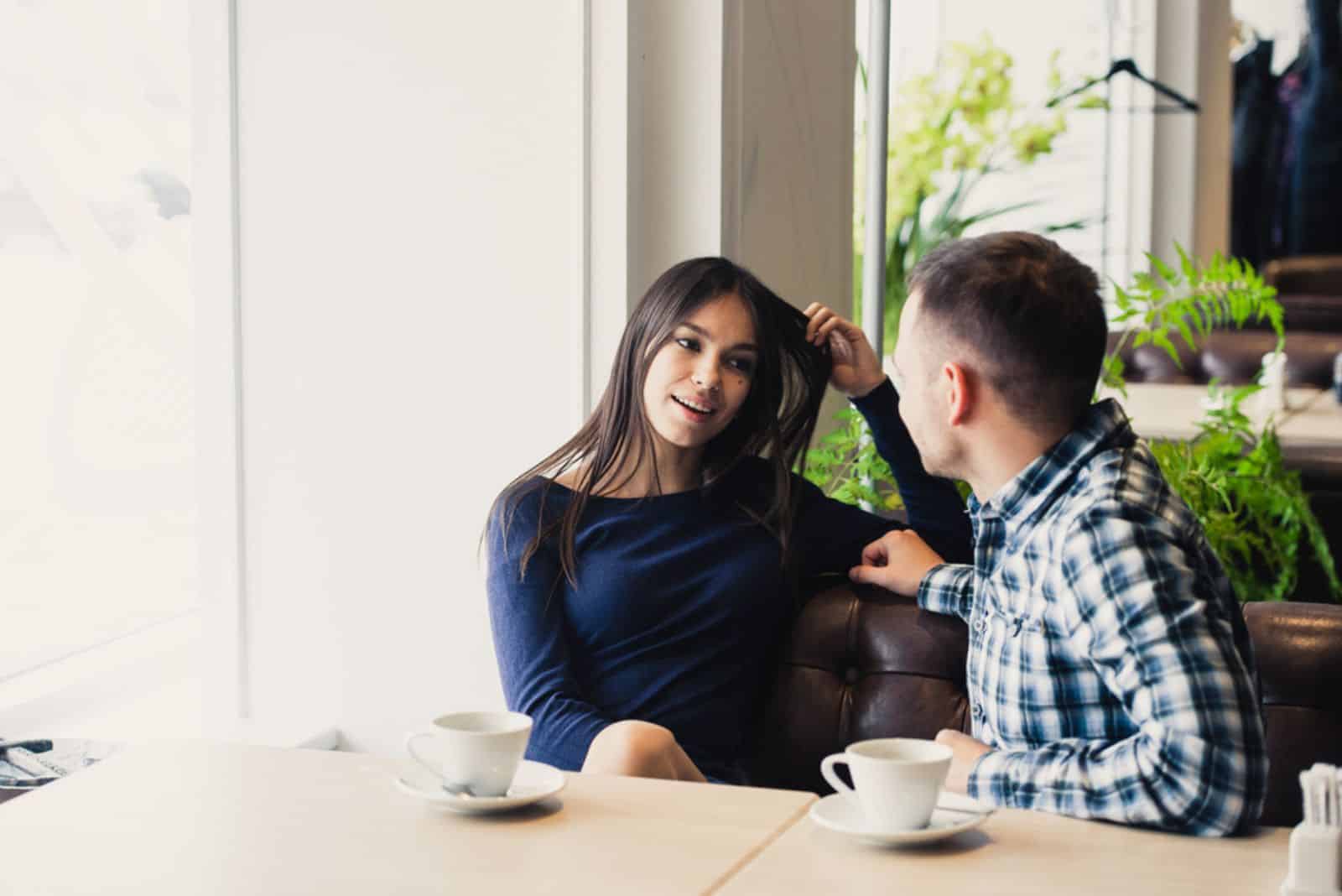 Casal feliz a conversar num café,