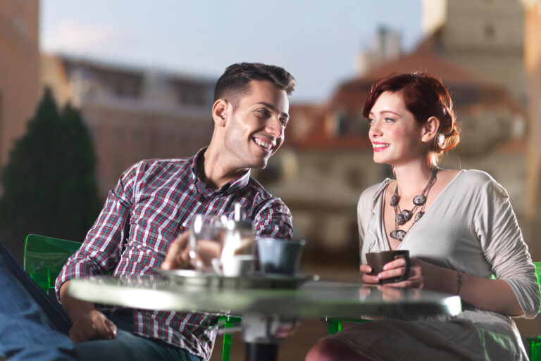 two coworkers sitting at cafe flirting
