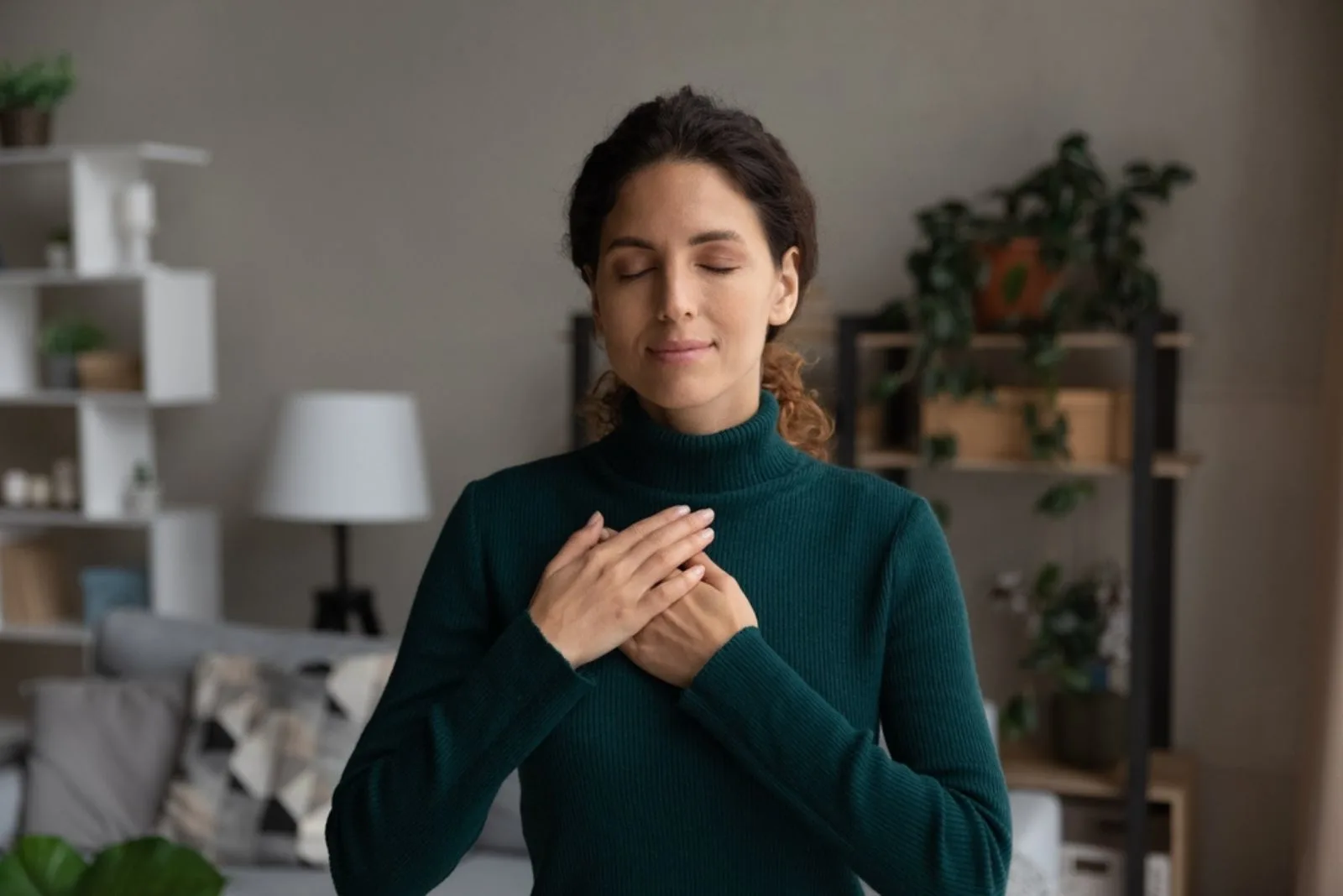 calm woman with closed eyes and hands on chest