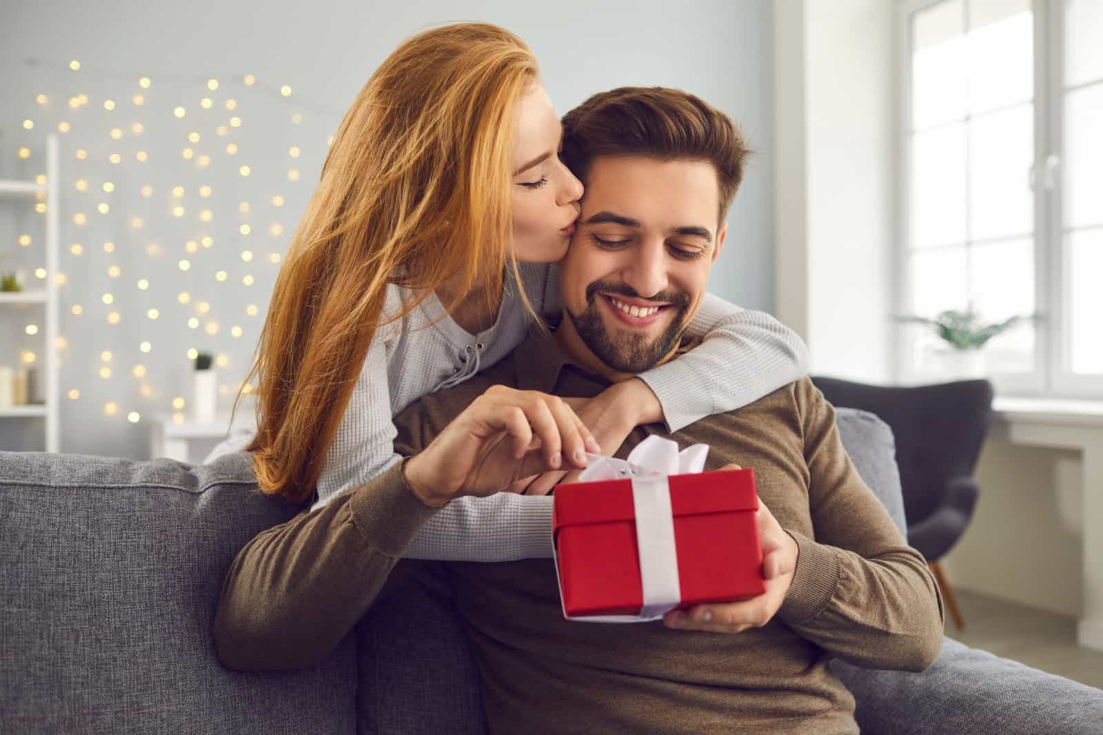woman gives present to boyfriend on his birthday