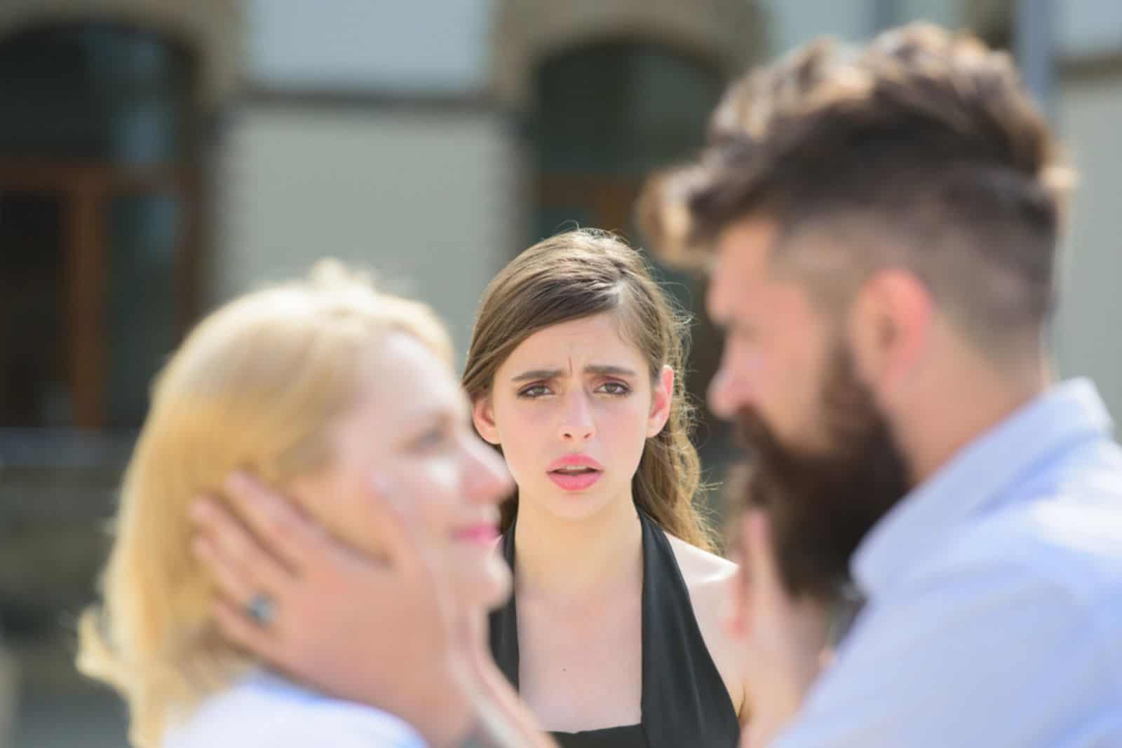 Jealous girl look at couple in love on street