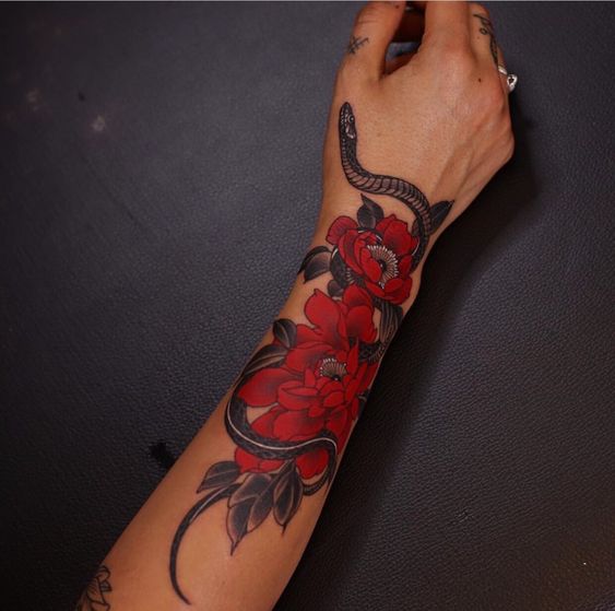 Snake and red flowers tattoo