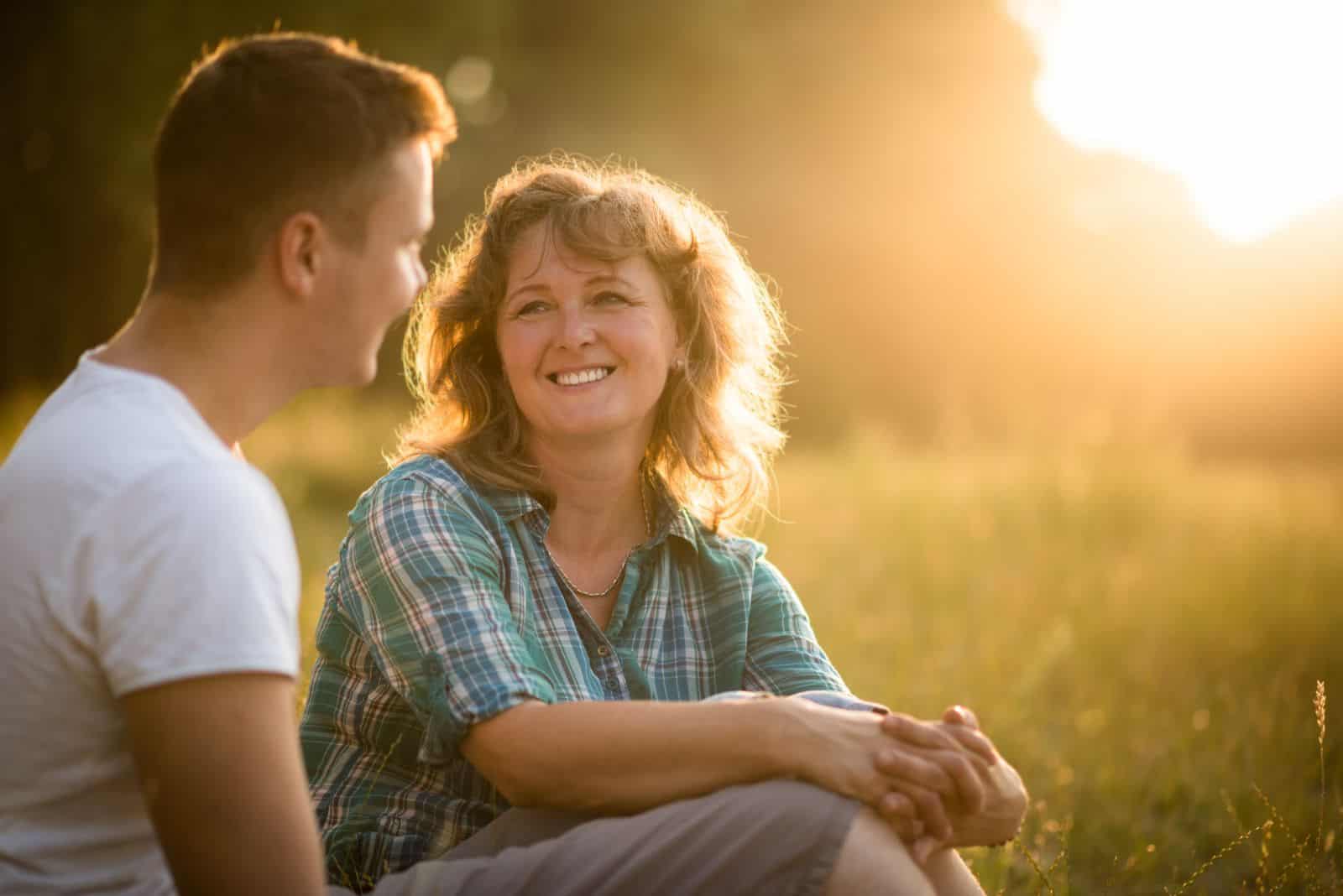 a smiling woman is talking to her son