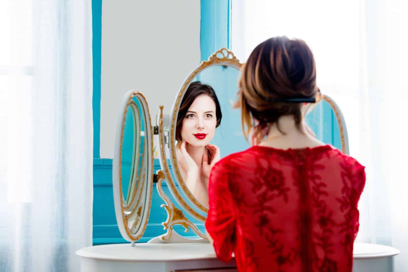 a beautiful girl is sitting in front of a mirror