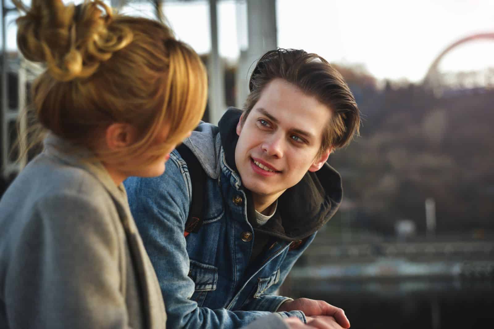 a man and a woman are standing next to each other and talking