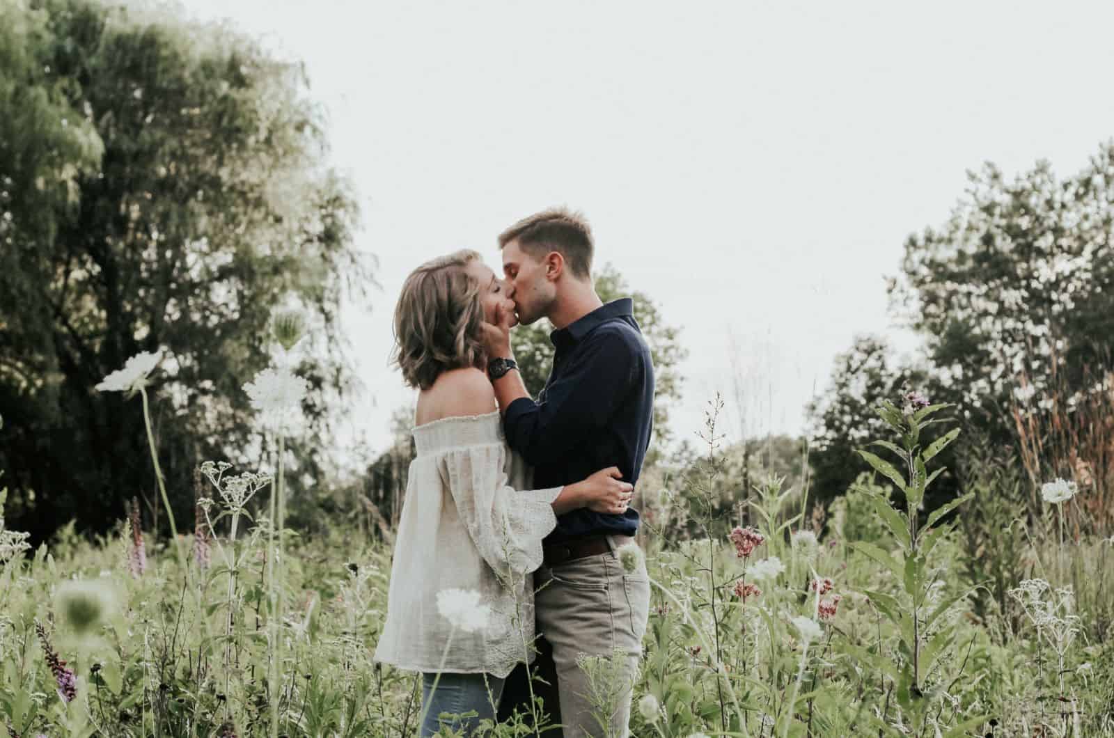 couple kissing in a field