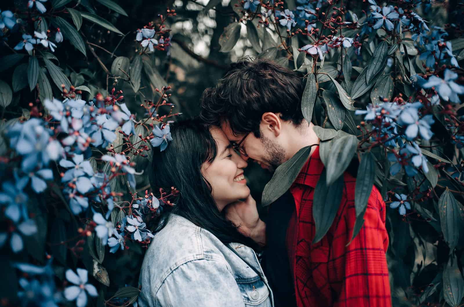 casal a beijar-se rodeado de ramos