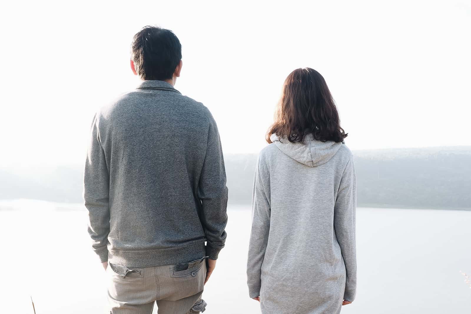 coppia in piedi di fronte al lago di sfondo