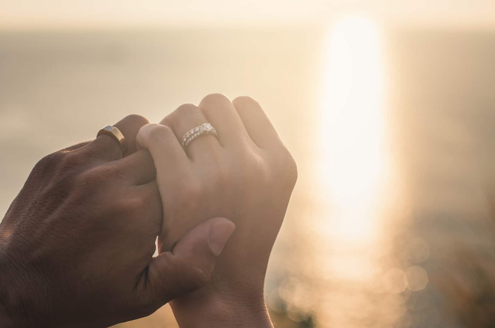 couple with wedding bands holding hands
