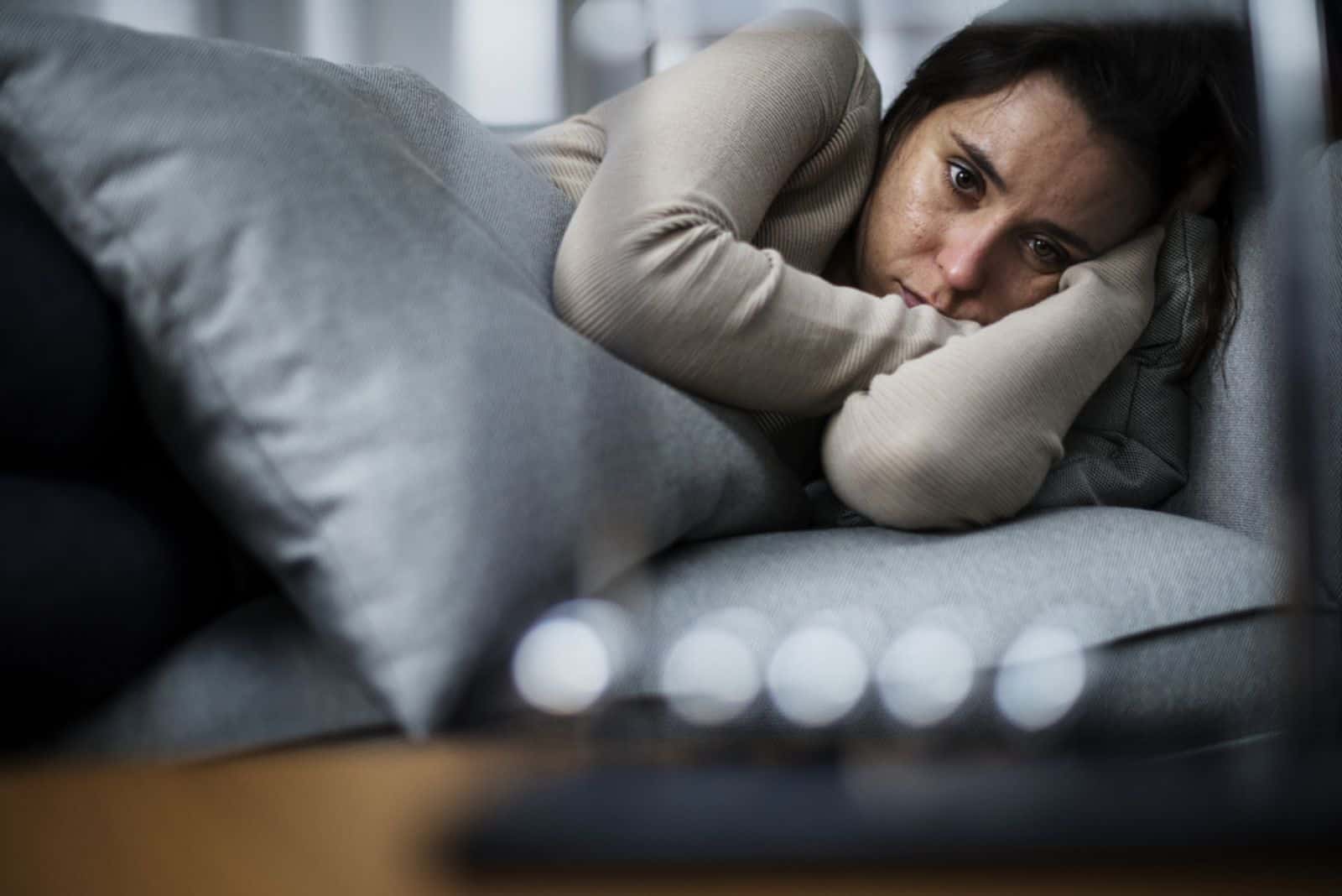 mujer deprimida tumbada en el sofá