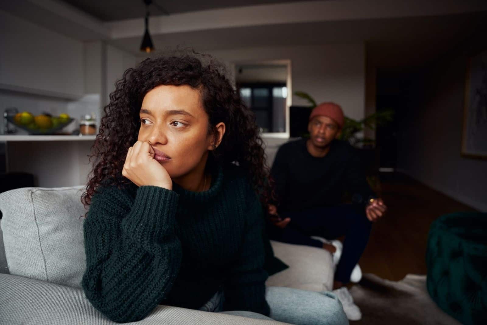 mujer ignorando a su novio mientras pelea en el sofá