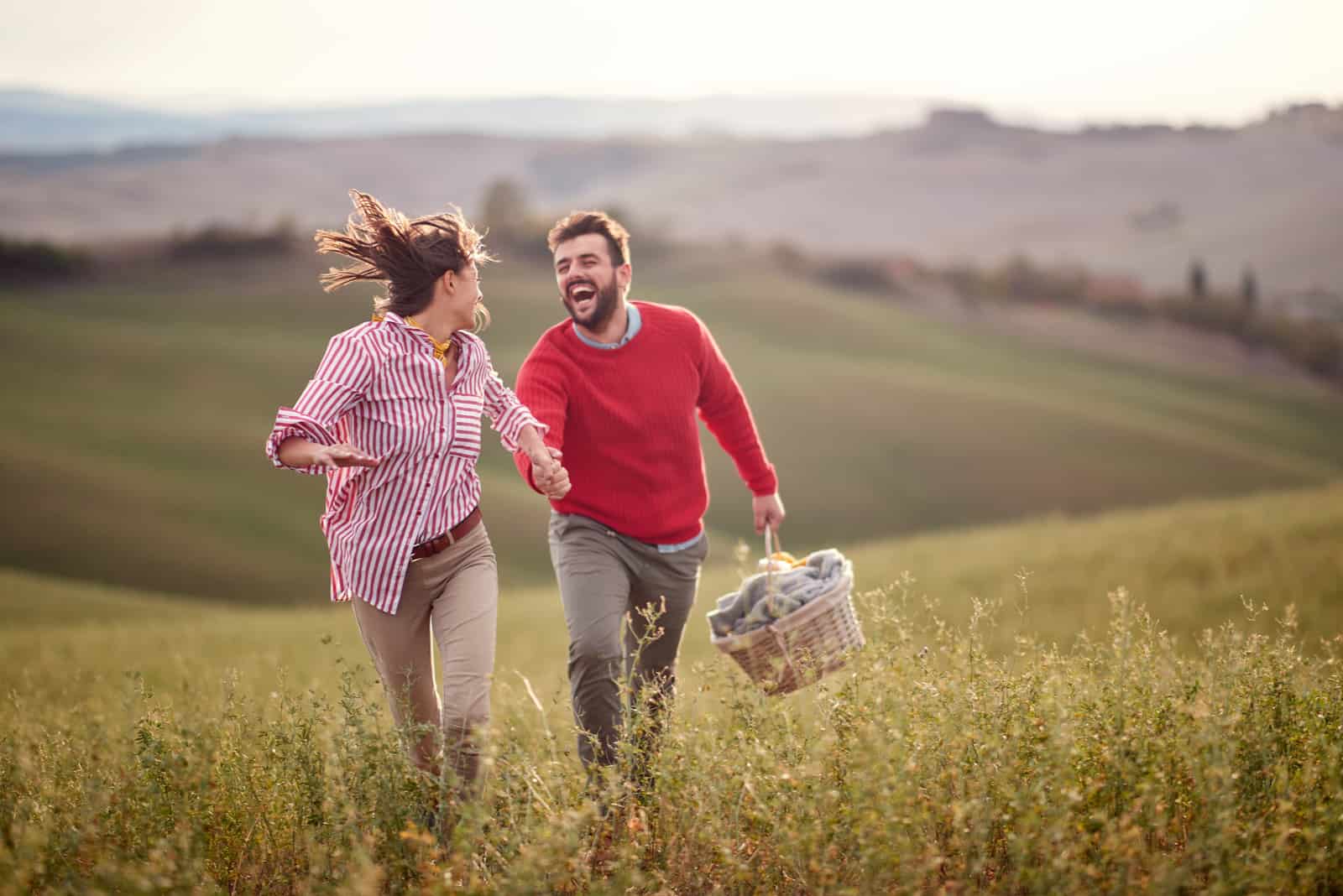 happy couple running on field