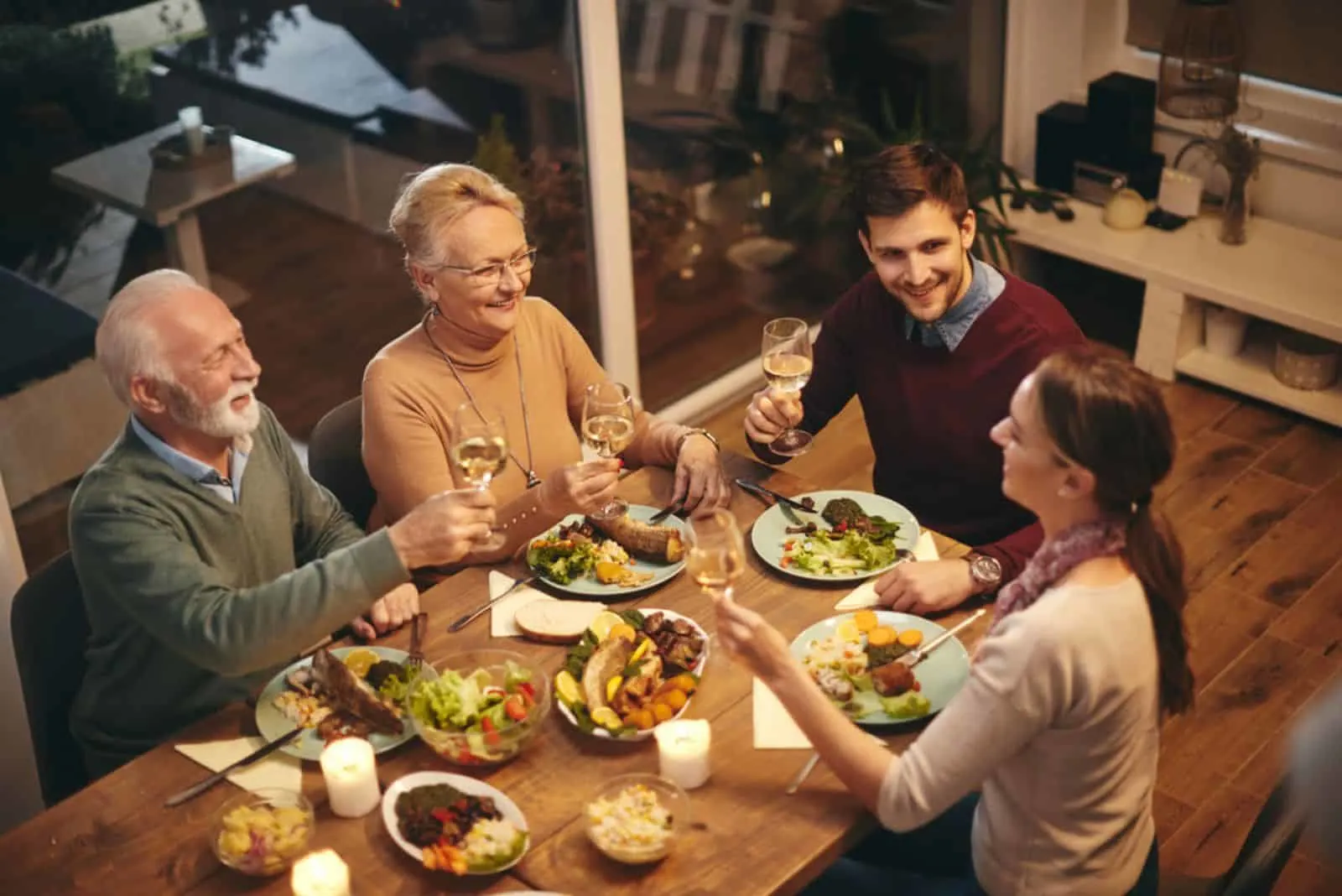 happy senior woman toasting with her family while having a meal