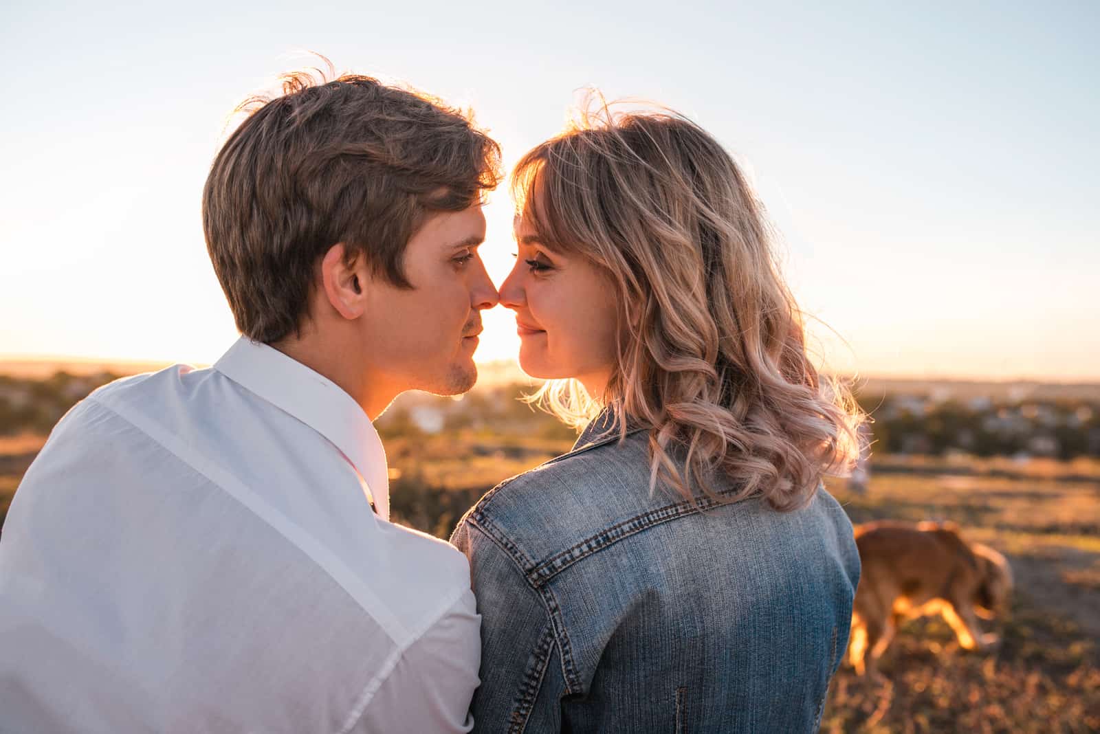 homem e mulher a beijarem-se durante o pôr do sol