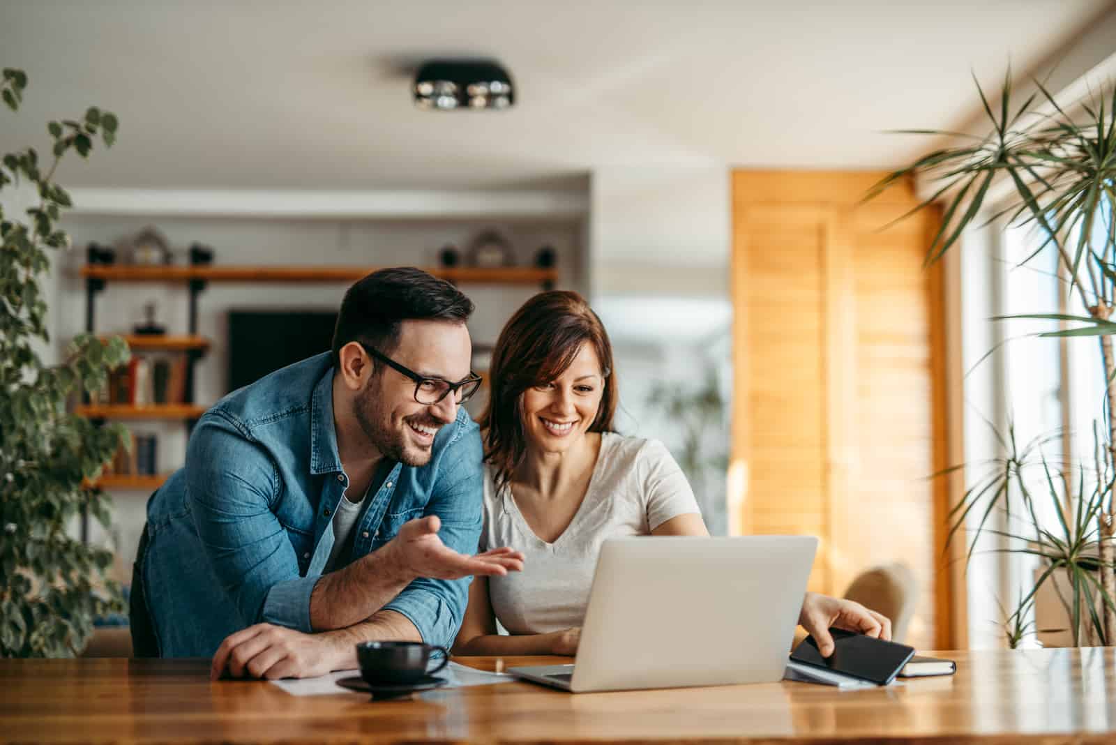 man and woman looking at somthing at laptop