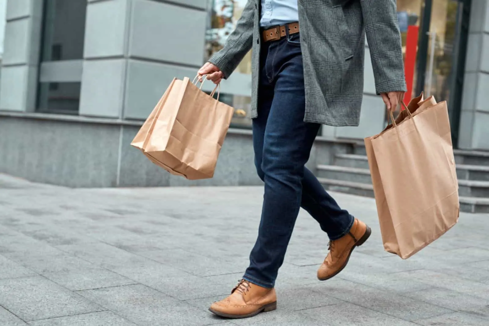  man in denim casual wear holding shopping paper bags