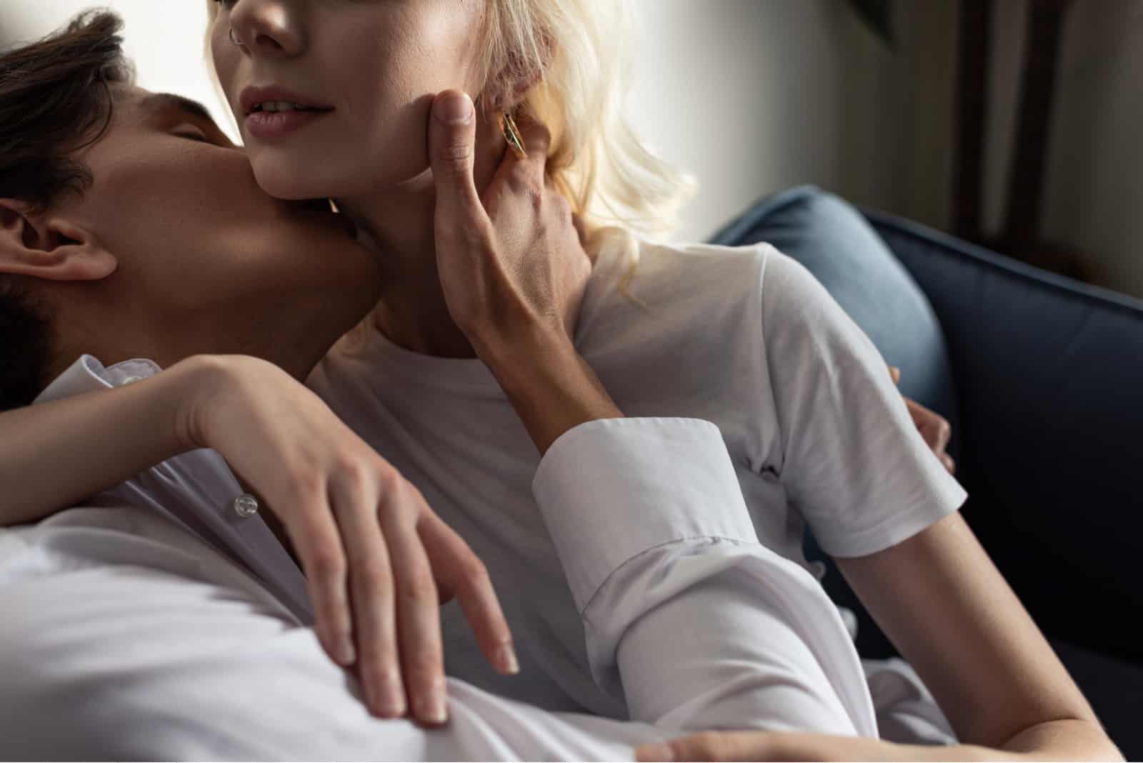 man kissing a woman on the neck