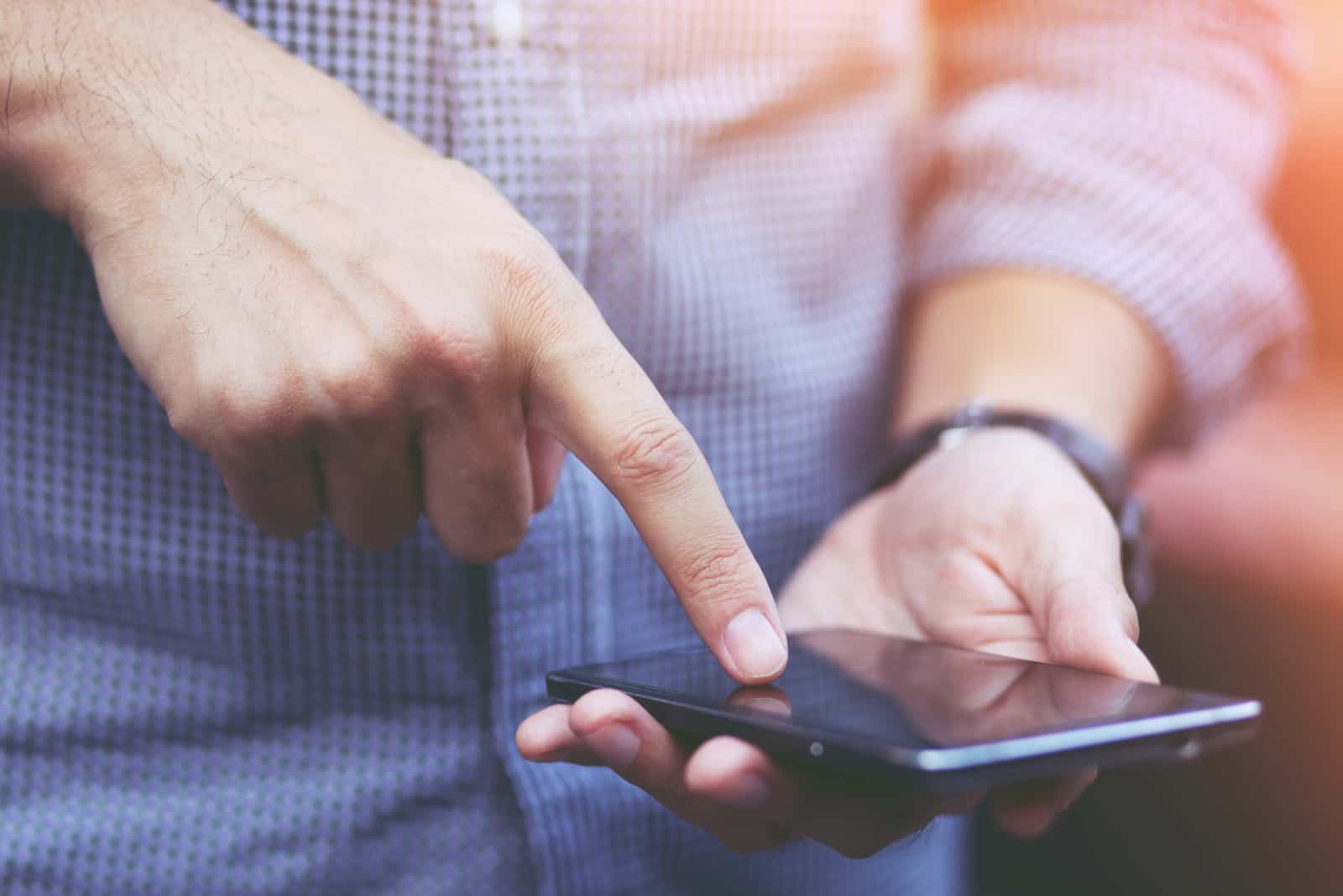 man touching mobile phone screen