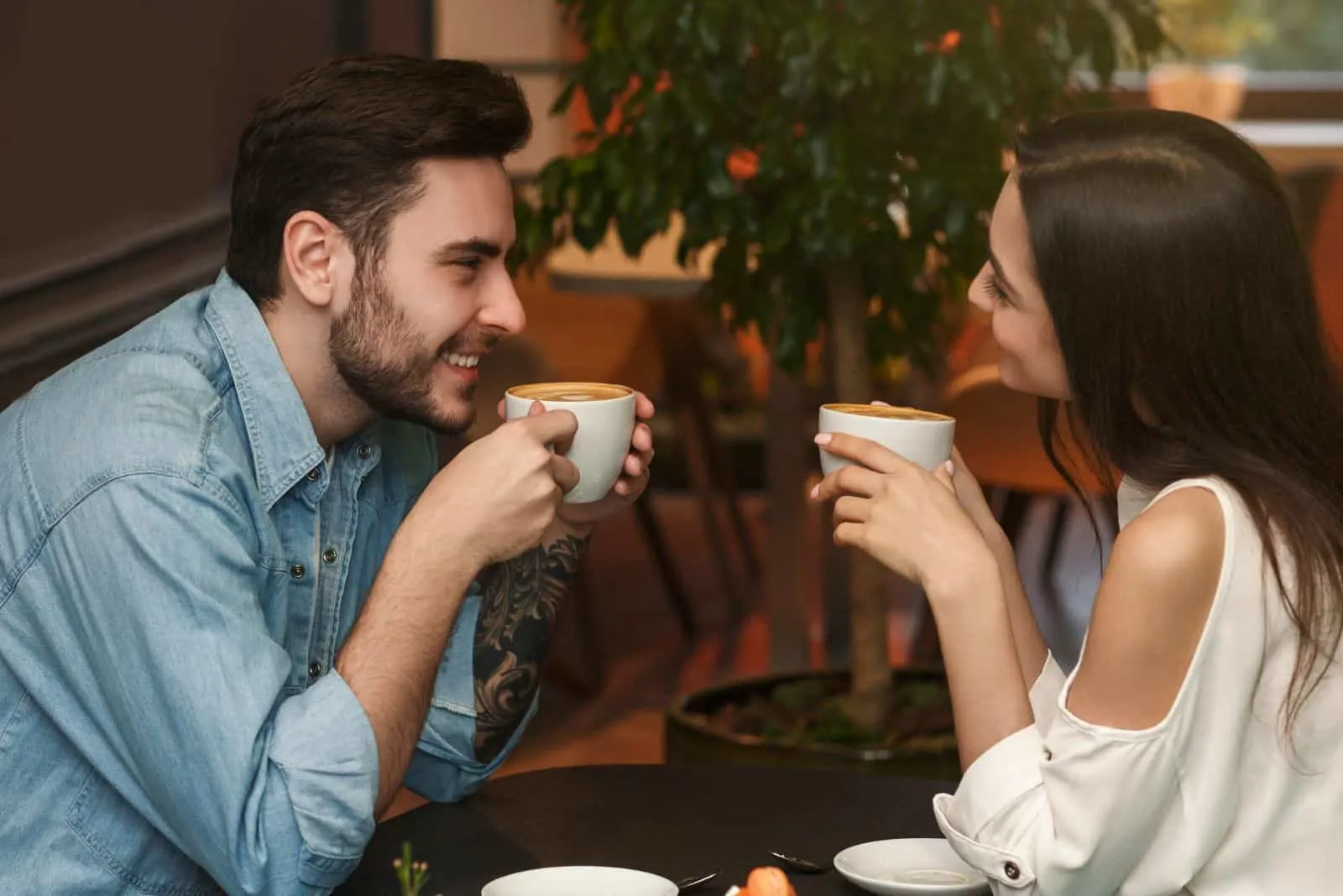 smiling man and woman enjoy talking over coffee