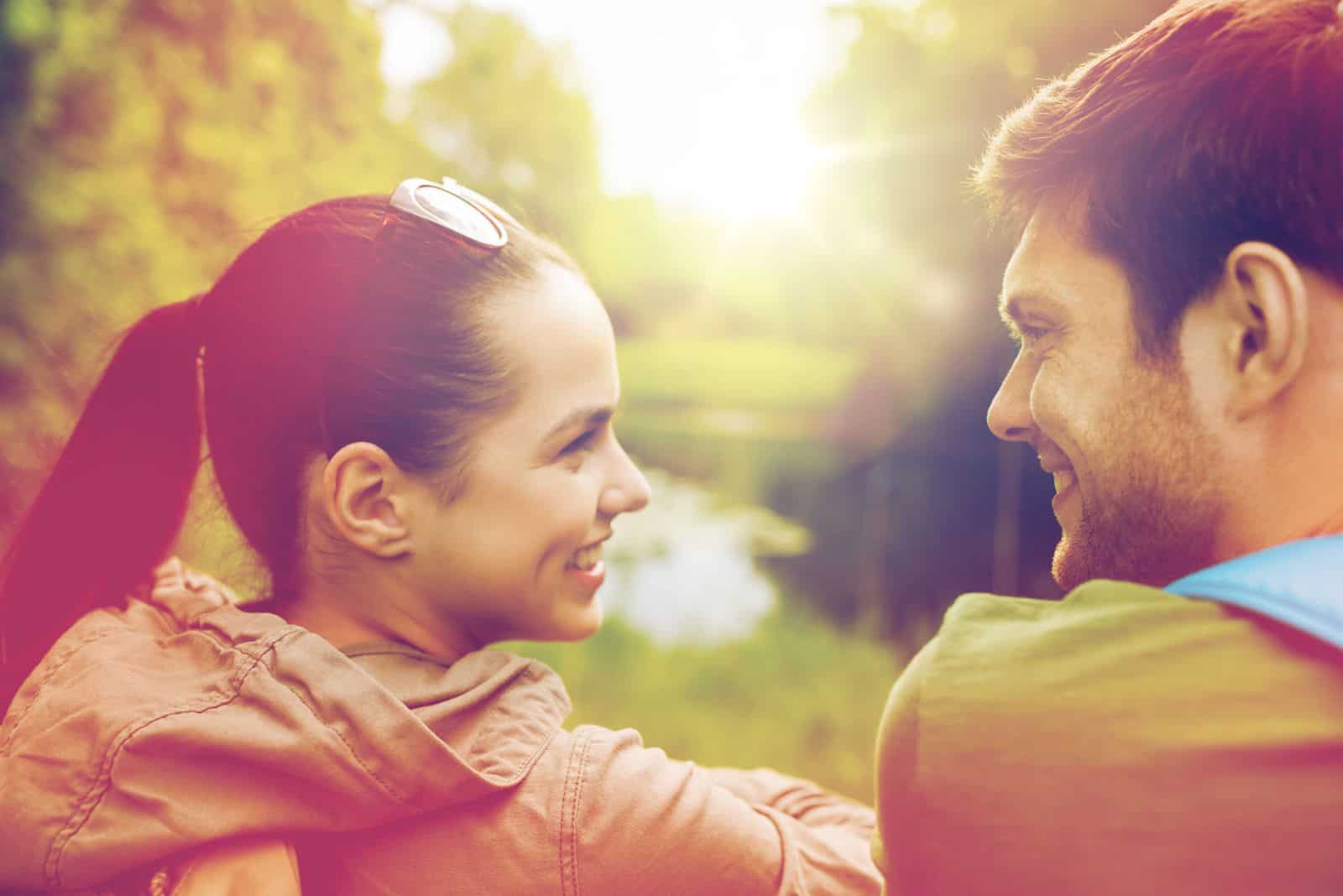 smiling man and woman sitting next to each other and looking at each other