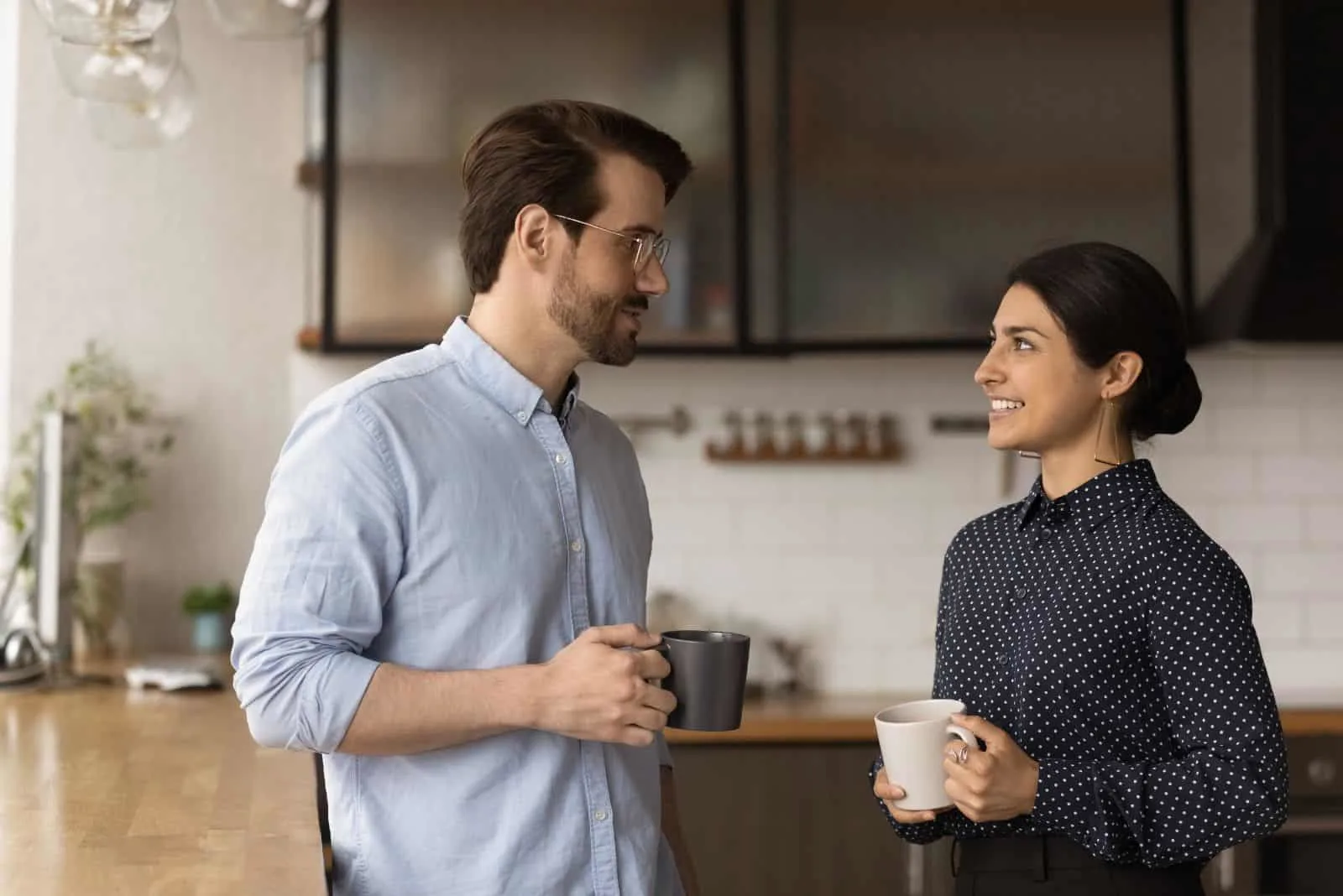 smiling woman talking over coffee with a man at work