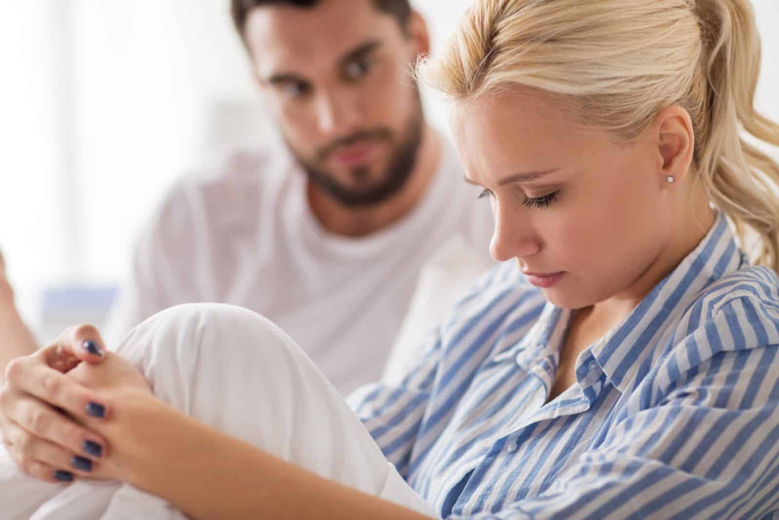  pareja infeliz discutiendo en la cama en casa