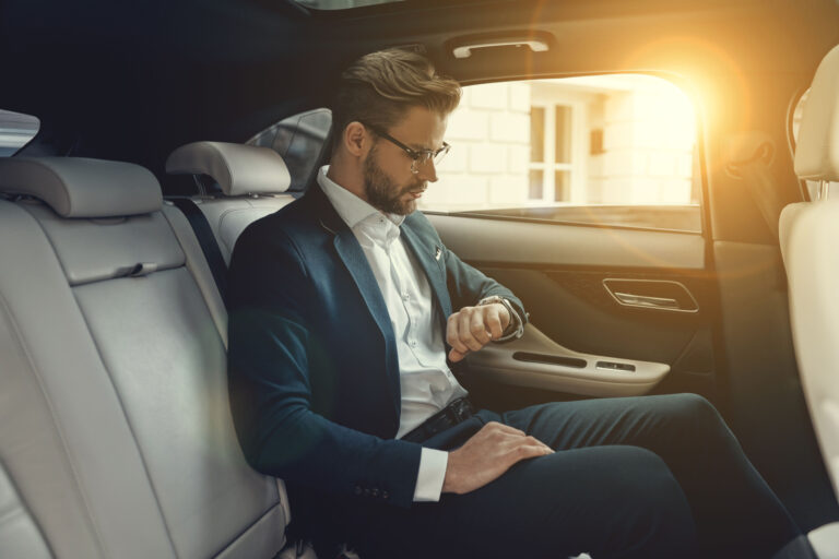 busy man sitting in his car checking out his watch