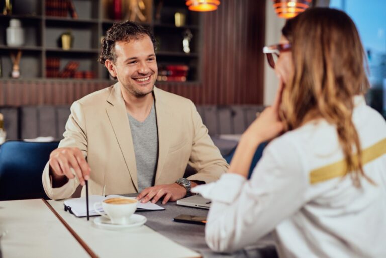 a beautiful smiling man is talking to a woman